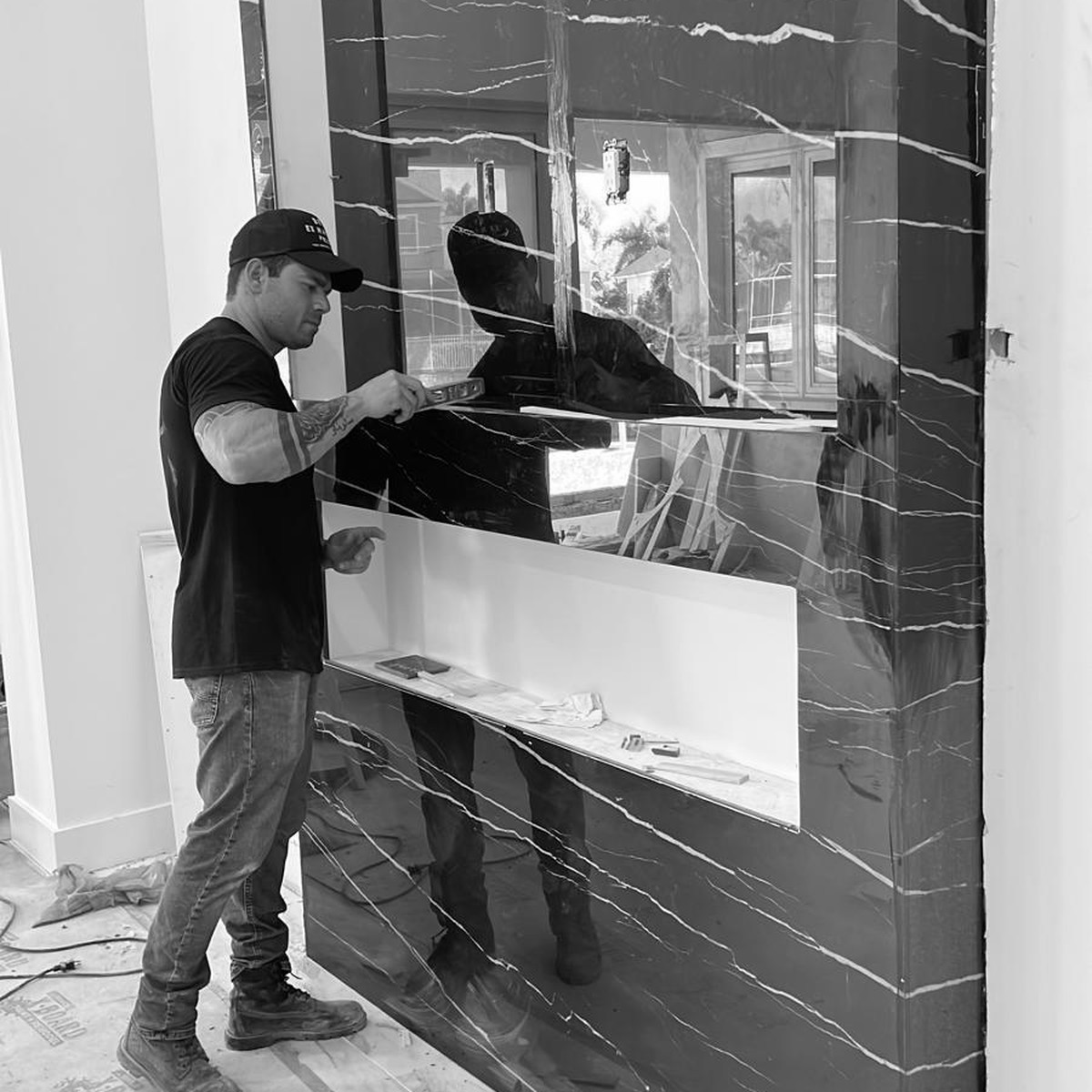 Fabricator installing a dramatic black stone feature wall
